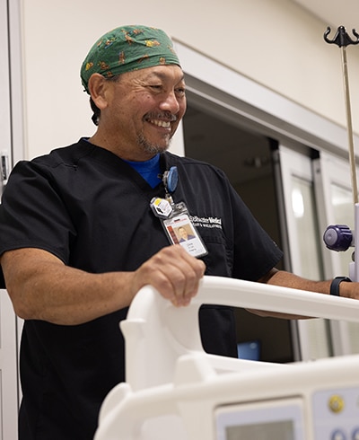 Provider standing at a patients bed